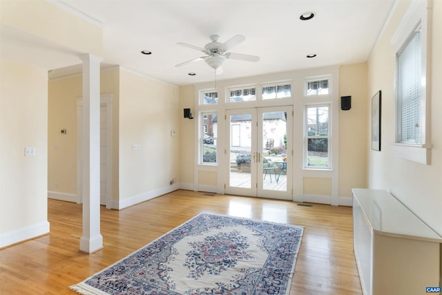 doorway to outside featuring decorative columns, french doors, ceiling fan, and light wood-type flooring