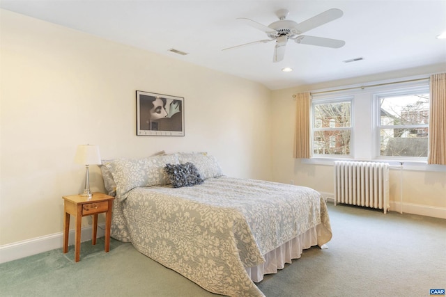 carpeted bedroom with radiator heating unit and ceiling fan