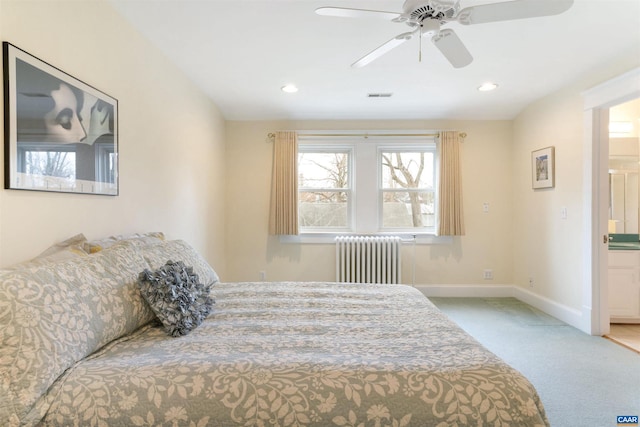 carpeted bedroom featuring ceiling fan, radiator heating unit, and ensuite bathroom