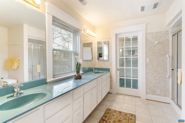 bathroom featuring vanity, a shower with shower door, tile patterned floors, and tile walls