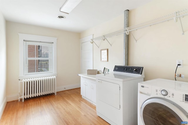 washroom with cabinets, radiator, washer and clothes dryer, and light wood-type flooring