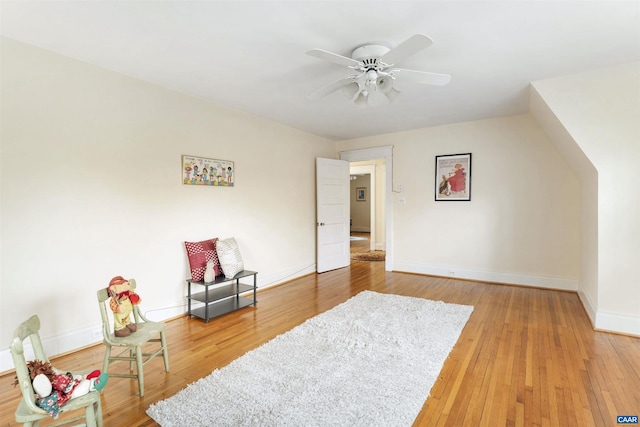 living area with ceiling fan and wood-type flooring