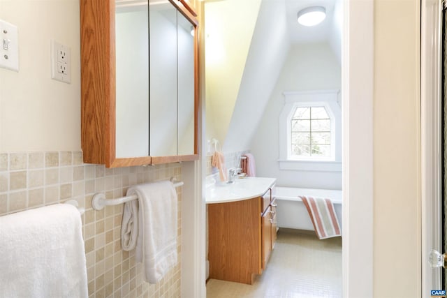 bathroom with vanity, vaulted ceiling, and decorative backsplash