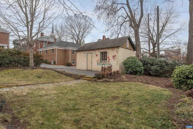 exterior space featuring an outdoor structure and a front lawn