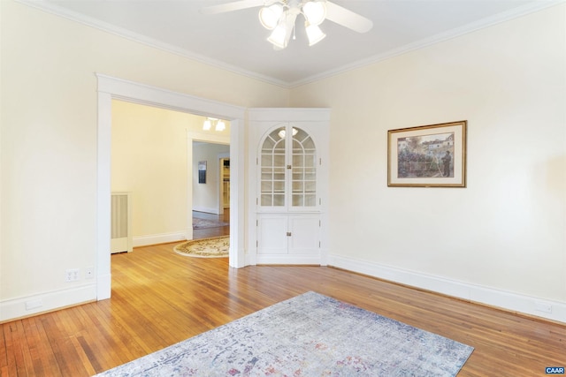 unfurnished room featuring hardwood / wood-style flooring, ceiling fan, and ornamental molding