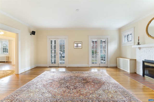 living room with radiator, light wood-type flooring, and french doors