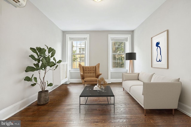 living room with an AC wall unit, a wealth of natural light, and dark hardwood / wood-style flooring