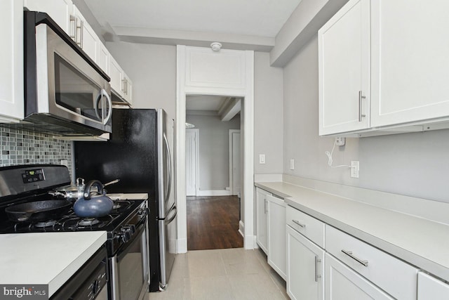 kitchen with white cabinetry, gas stove, and tasteful backsplash