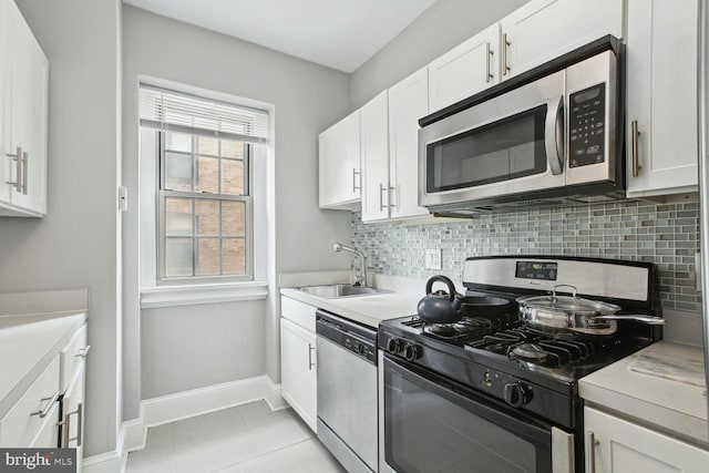 kitchen featuring tasteful backsplash, white cabinetry, appliances with stainless steel finishes, and sink