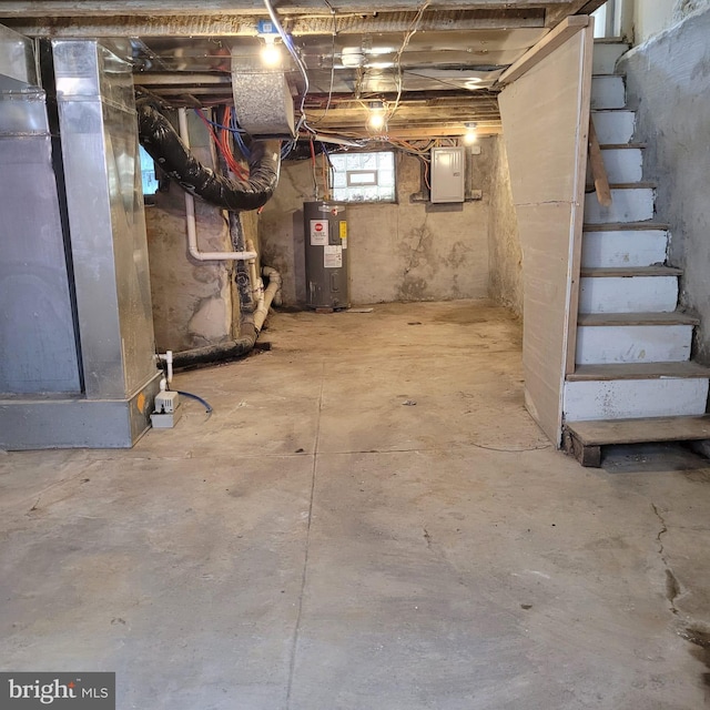 basement featuring electric panel and water heater