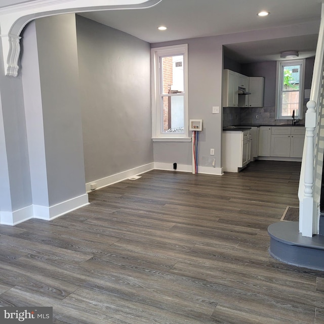 unfurnished living room featuring dark hardwood / wood-style floors and sink