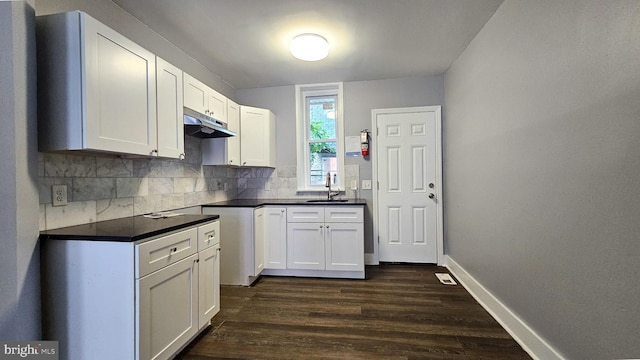 kitchen with white cabinetry, sink, dark hardwood / wood-style flooring, and decorative backsplash