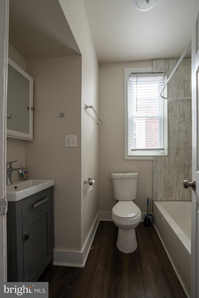 full bathroom featuring hardwood / wood-style flooring, vanity, tiled shower / bath combo, and toilet