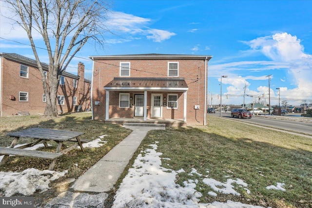 view of front of house with a front yard and covered porch