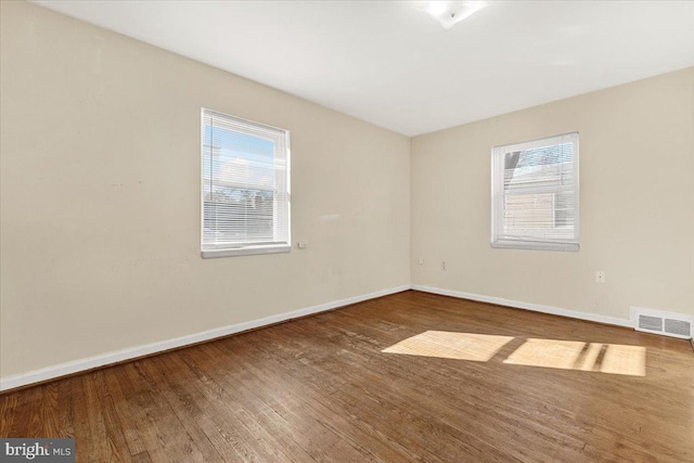 spare room with hardwood / wood-style floors and a wealth of natural light