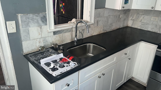 kitchen with white cabinetry, sink, and backsplash