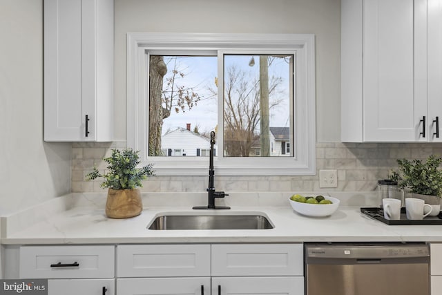 kitchen with sink, white cabinetry, light stone counters, dishwasher, and backsplash