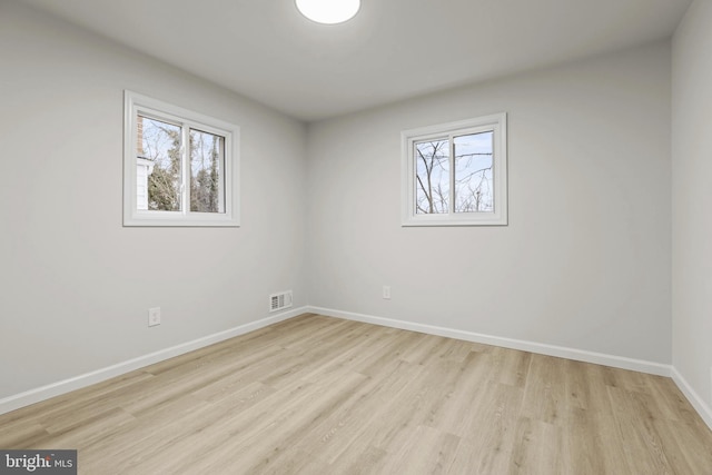 spare room with a healthy amount of sunlight and light hardwood / wood-style flooring