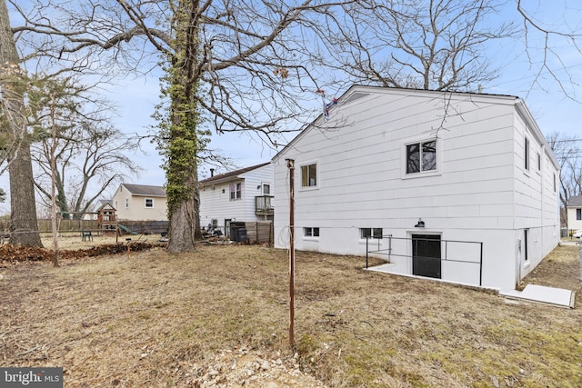 rear view of property with a yard and a playground