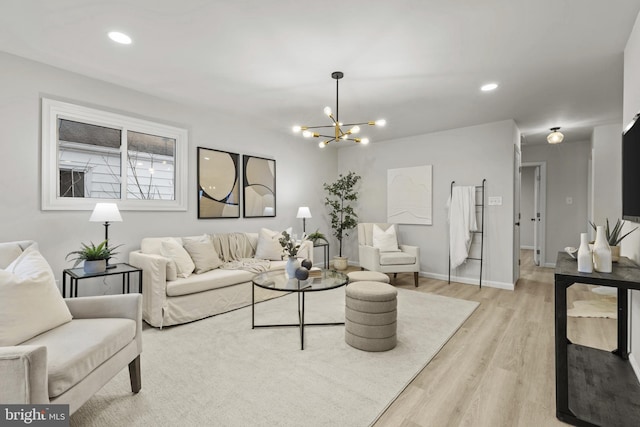 living room featuring a notable chandelier and light wood-type flooring