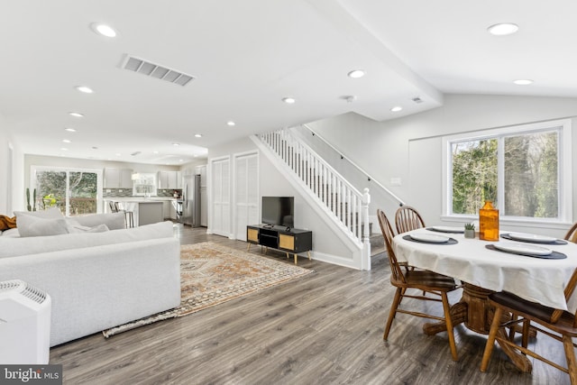 dining space featuring wood-type flooring and lofted ceiling