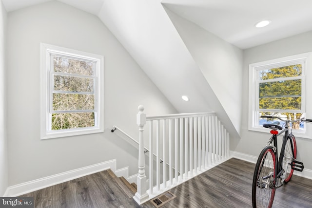 stairs with hardwood / wood-style flooring, vaulted ceiling, and a healthy amount of sunlight