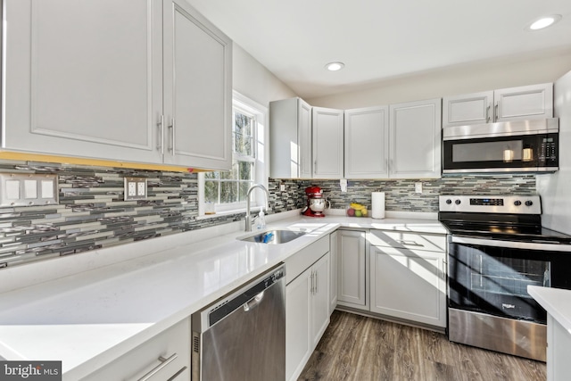 kitchen featuring tasteful backsplash, sink, dark wood-type flooring, and stainless steel appliances