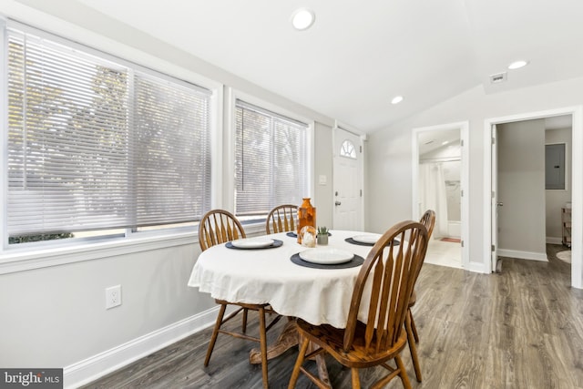 dining area featuring wood-type flooring, lofted ceiling, and electric panel