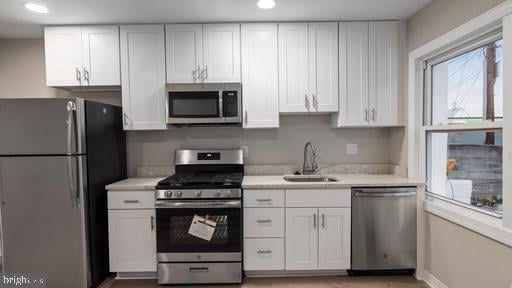 kitchen with sink, stainless steel appliances, and white cabinets