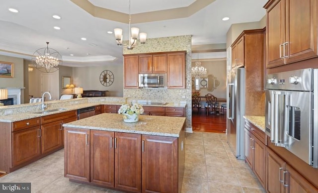 kitchen featuring a chandelier, stainless steel appliances, a raised ceiling, and kitchen peninsula