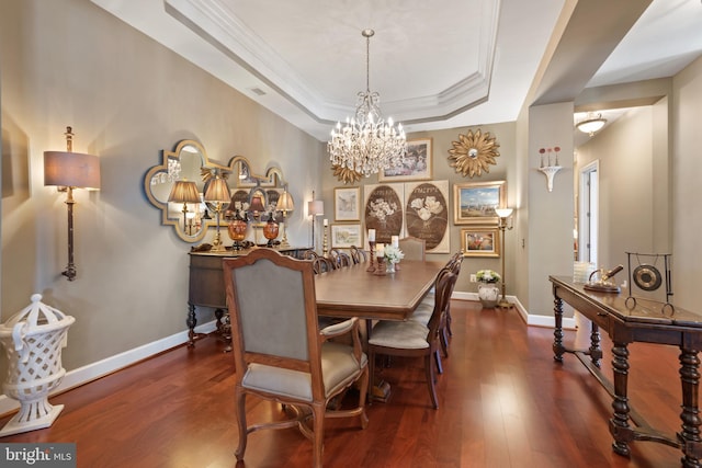 dining area with a raised ceiling, crown molding, and dark hardwood / wood-style floors