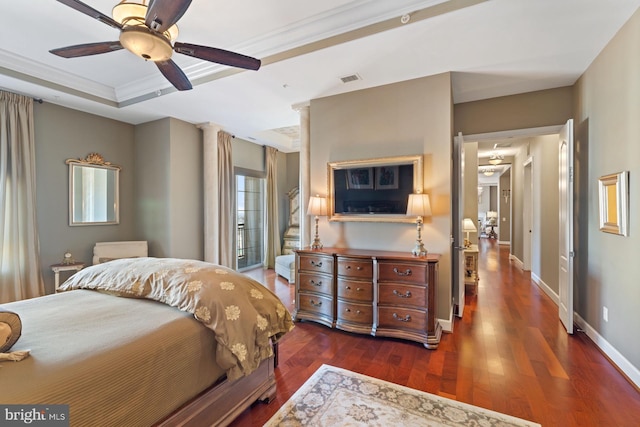 bedroom with ceiling fan, ornamental molding, dark hardwood / wood-style floors, and a tray ceiling