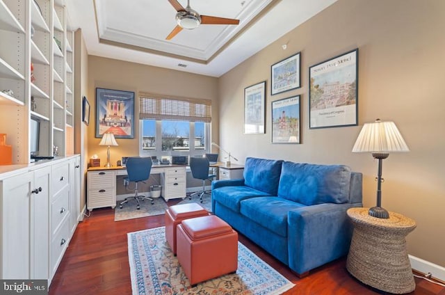 office area featuring dark hardwood / wood-style flooring, a tray ceiling, crown molding, and ceiling fan