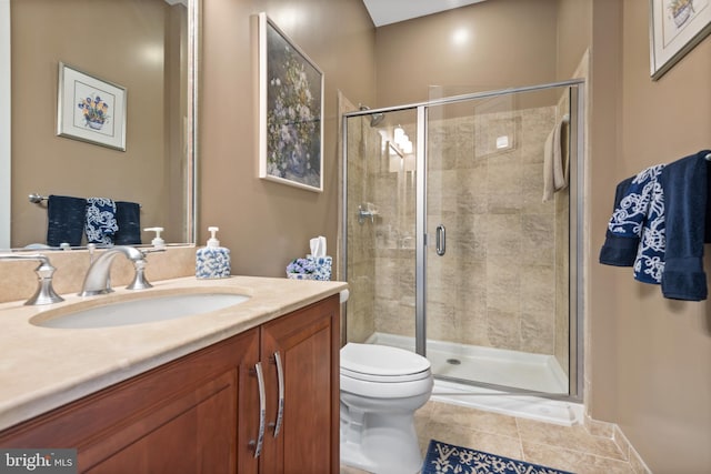 bathroom with vanity, tile patterned flooring, a shower with door, and toilet