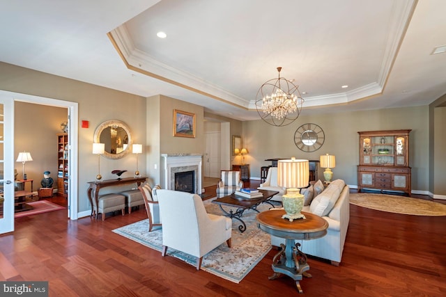 living room featuring crown molding, dark hardwood / wood-style floors, a high end fireplace, and a raised ceiling