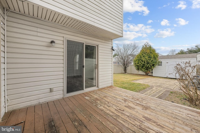 wooden terrace featuring an outbuilding and a patio area