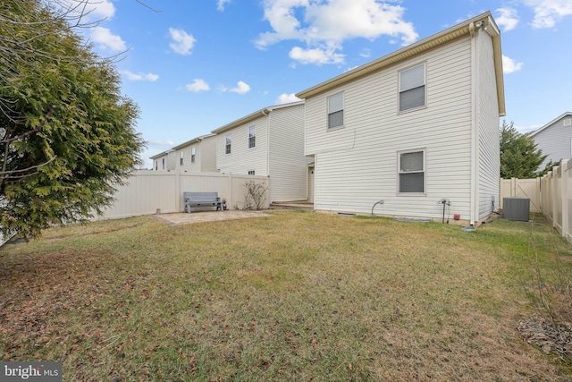 rear view of house with cooling unit, a patio area, and a lawn