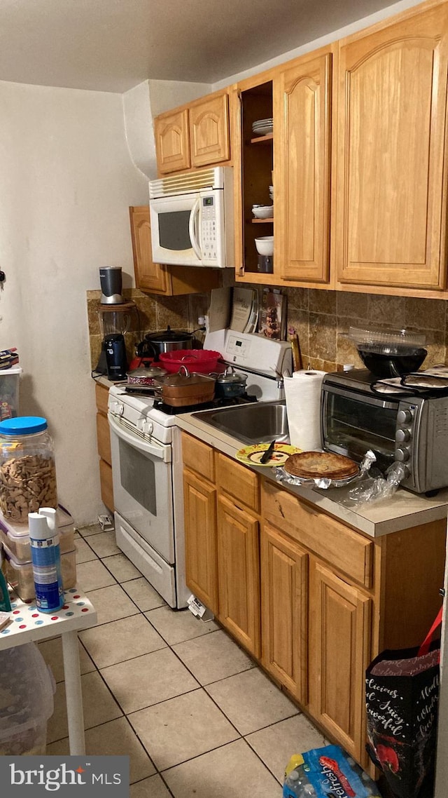 kitchen featuring tasteful backsplash, white appliances, and light tile patterned floors