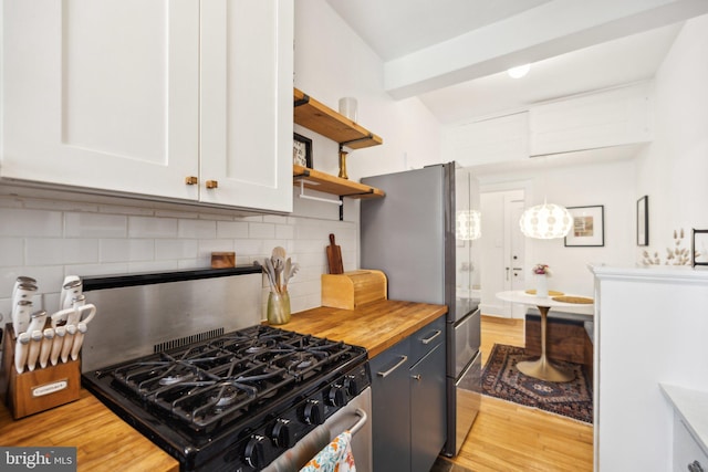 kitchen with tasteful backsplash, freestanding refrigerator, butcher block countertops, light wood-style floors, and white cabinetry
