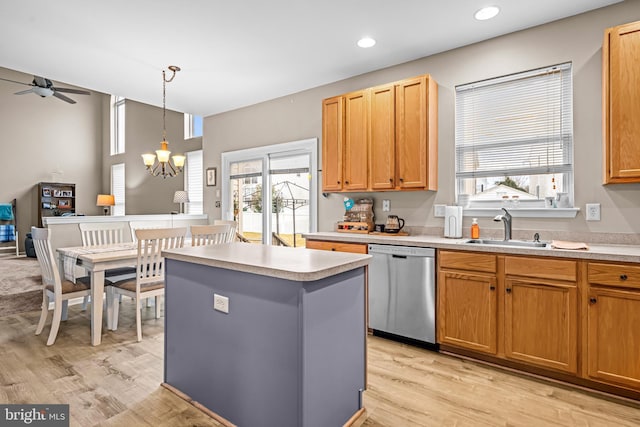 kitchen with sink, a center island, hanging light fixtures, light wood-type flooring, and dishwasher