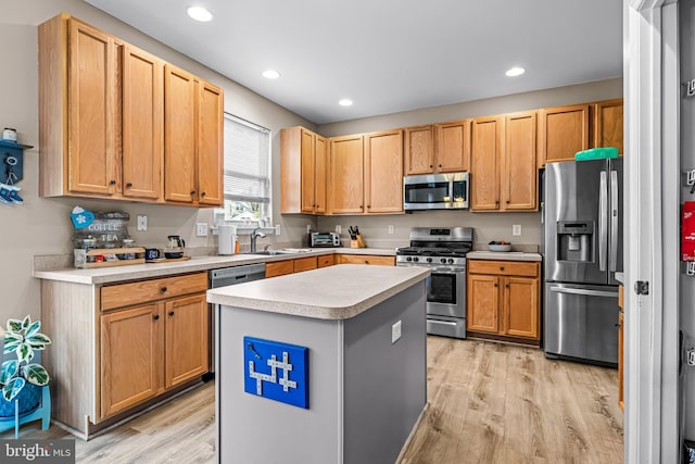 kitchen featuring stainless steel appliances, sink, a kitchen island, and light wood-type flooring