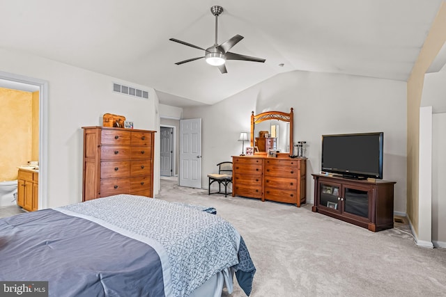 carpeted bedroom with vaulted ceiling, ceiling fan, and ensuite bathroom