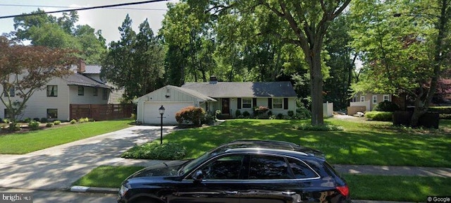 ranch-style house with an attached garage, driveway, and a front lawn