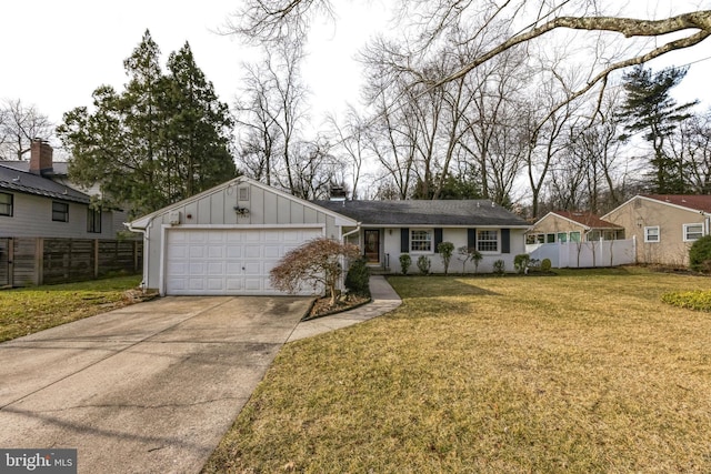 view of front of home with driveway, an attached garage, fence, a front lawn, and board and batten siding