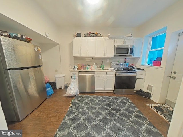 kitchen with tasteful backsplash, appliances with stainless steel finishes, dark hardwood / wood-style flooring, and white cabinets