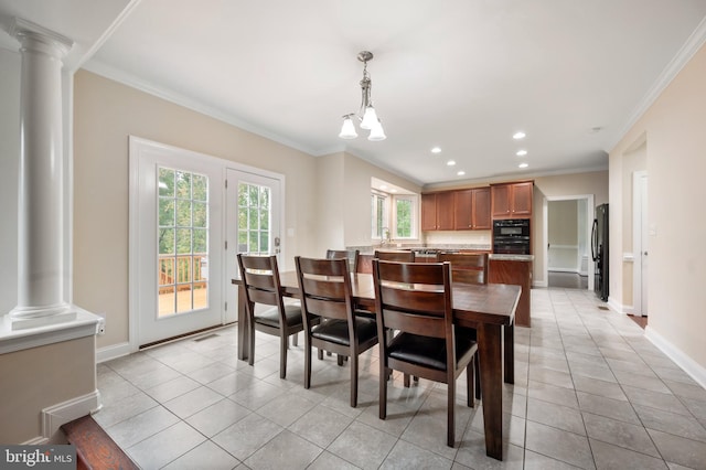 dining area with light tile patterned floors, ornamental molding, and ornate columns