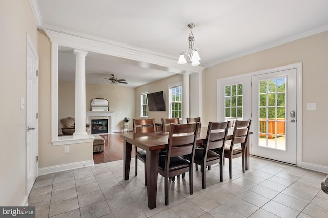 dining area with crown molding, ceiling fan, light tile patterned flooring, and ornate columns