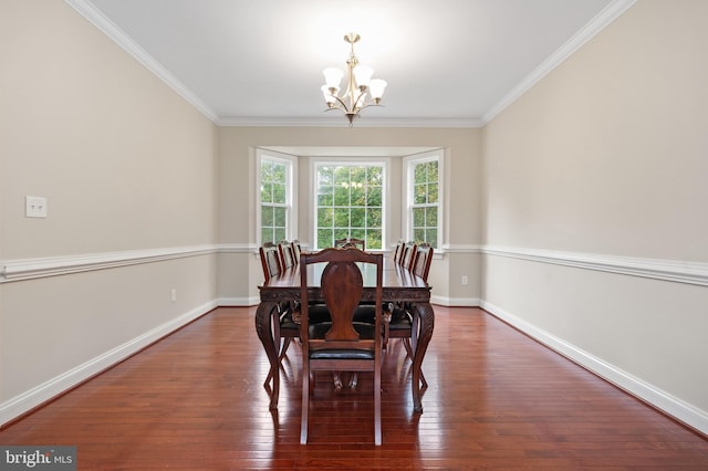 dining area featuring crown molding, dark hardwood / wood-style floors, and a chandelier