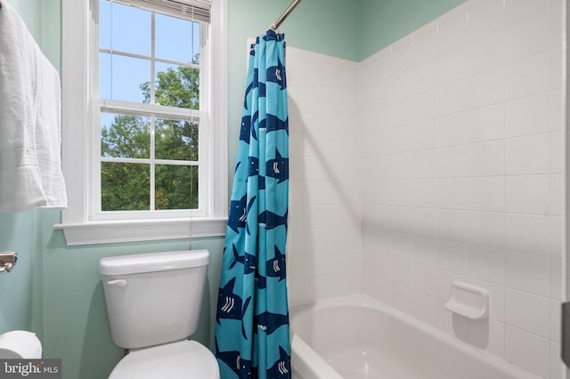 bathroom with plenty of natural light, shower / bath combination with curtain, and toilet