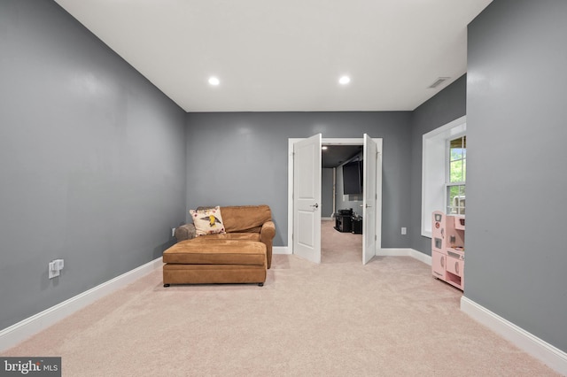 sitting room featuring light carpet